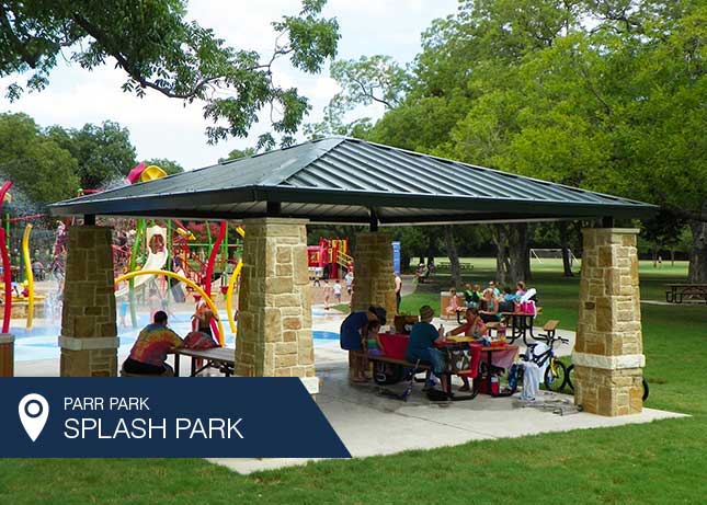 People eating under the Parr Park Shade Structure designed and installed by Kraftsman
