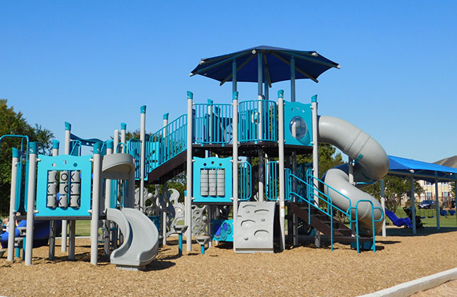 Giant playground with inclusive swings and multiple slides by Kraftsman