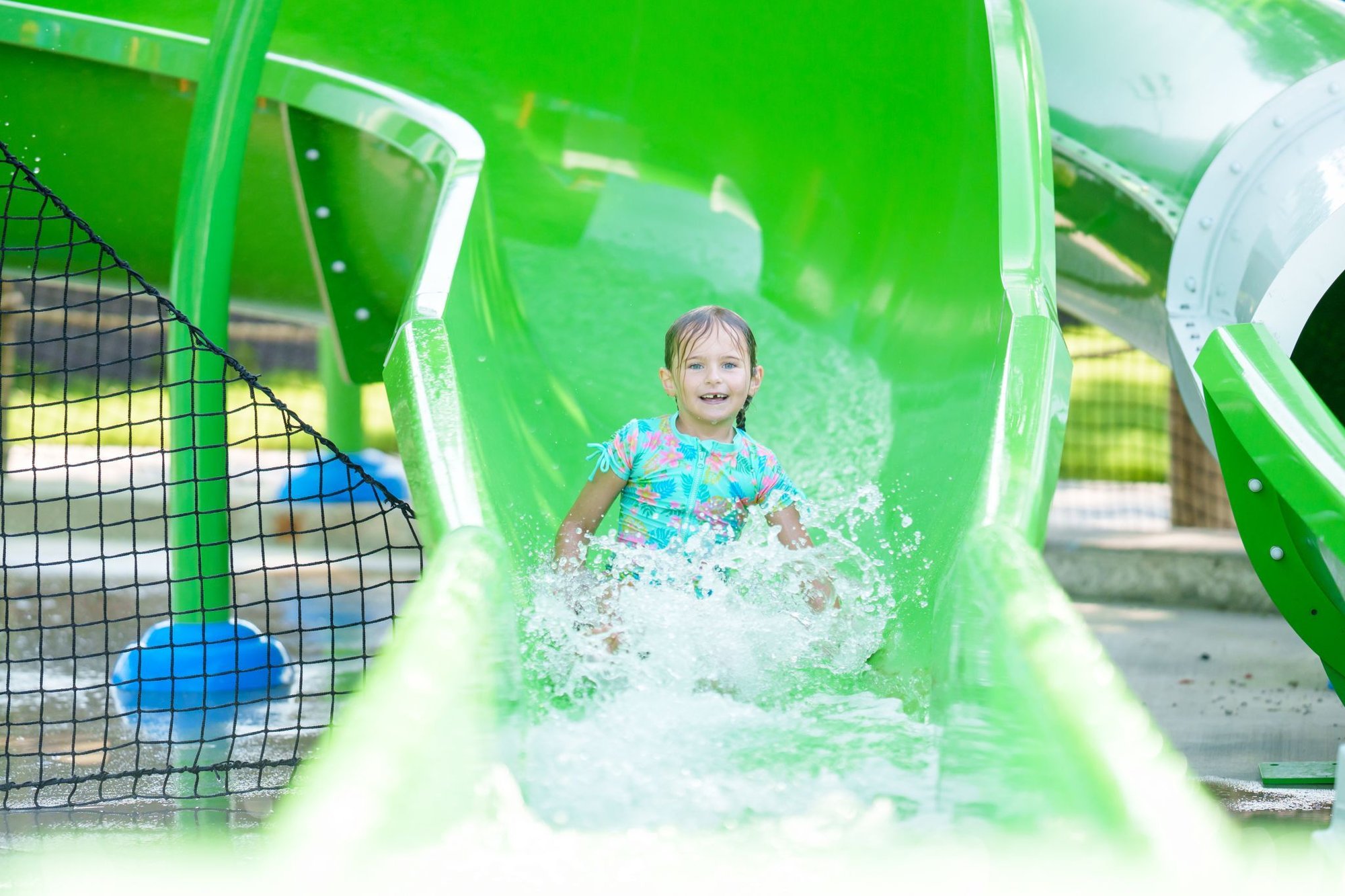 Child sliding down slide on Bahama Beach Waterpark's Elevations aquatic play structure with colorful waterslides in Dallas, Texas Child sliding down slide on Bahama Beach Waterpark's Elevations aquatic play structure with colorful waterslides in Dallas, Texas