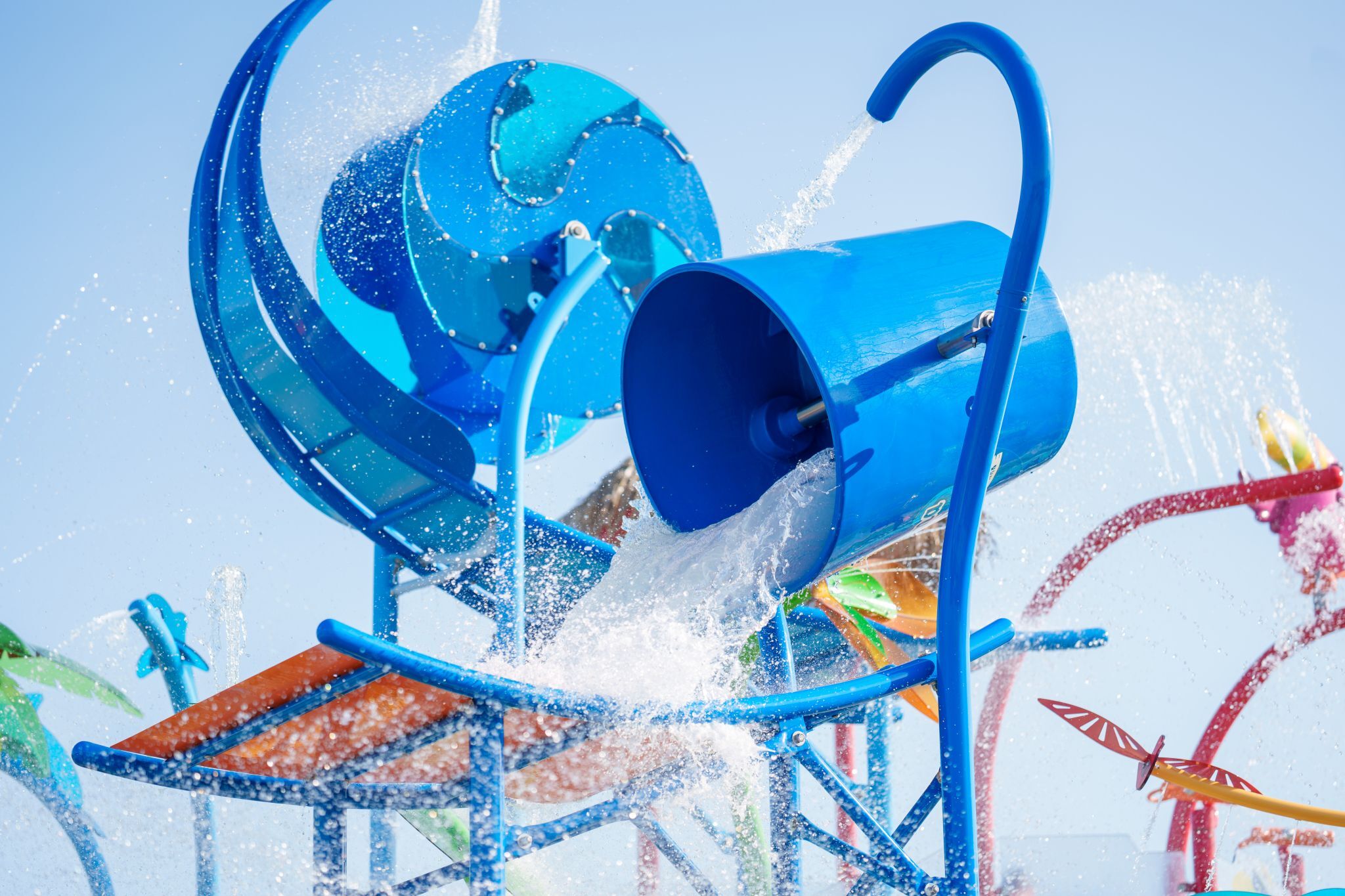 Splash bucket on Bahama Beach Waterpark's Elevations aquatic play structure with colorful waterslides in Dallas, Texas