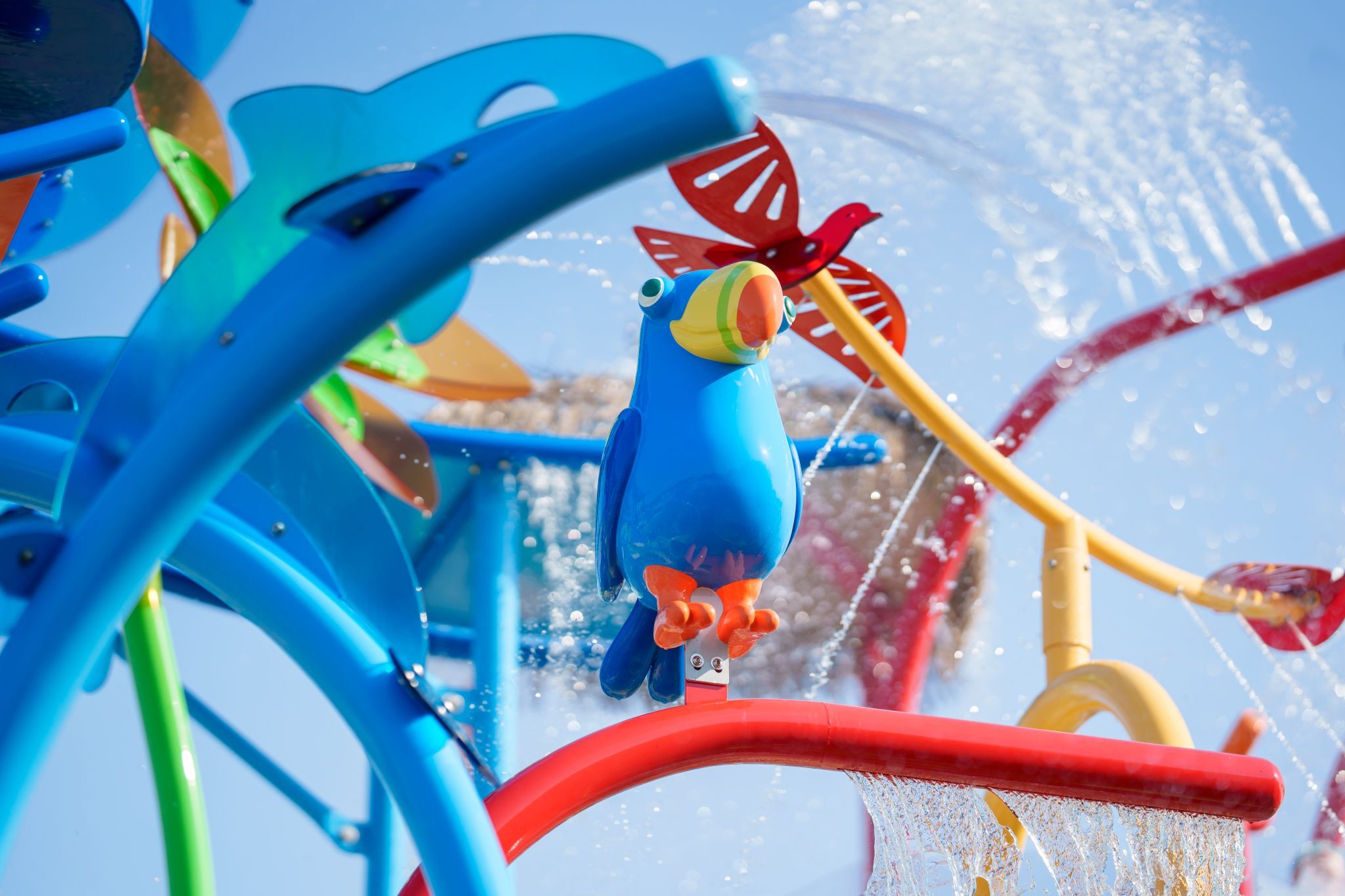 Parrot feature on Bahama Beach Waterpark's Elevations aquatic play structure with colorful waterslides in Dallas, Texas