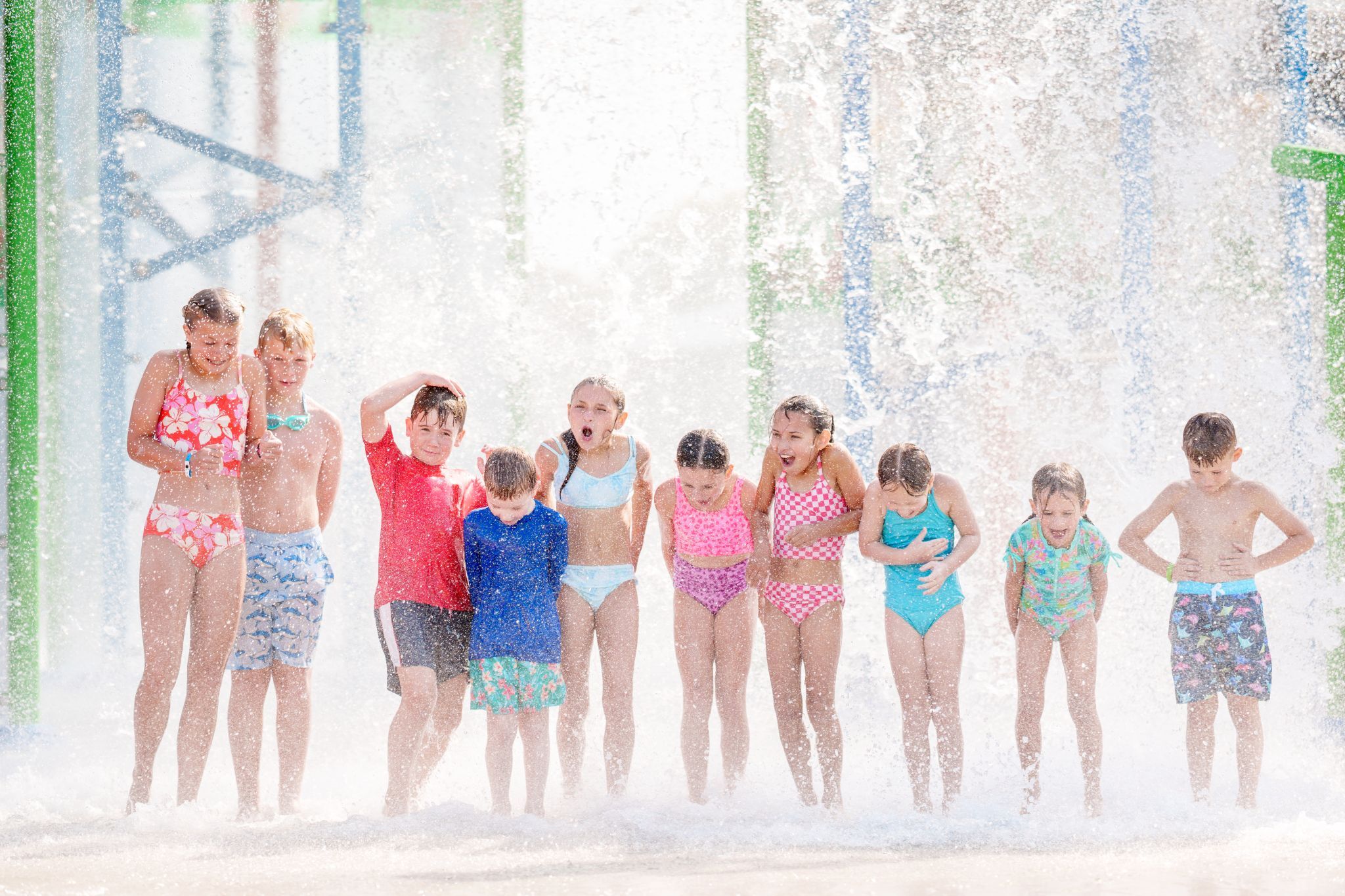 Children taking photo on Bahama Beach Waterpark's Elevations aquatic play structure with colorful waterslides in Dallas, Texas