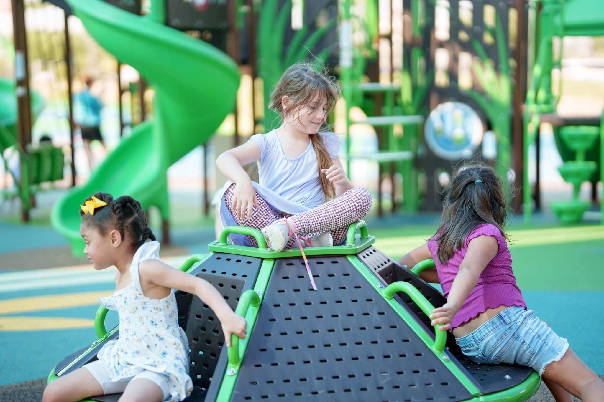children playing on atom spinner merry-go-round