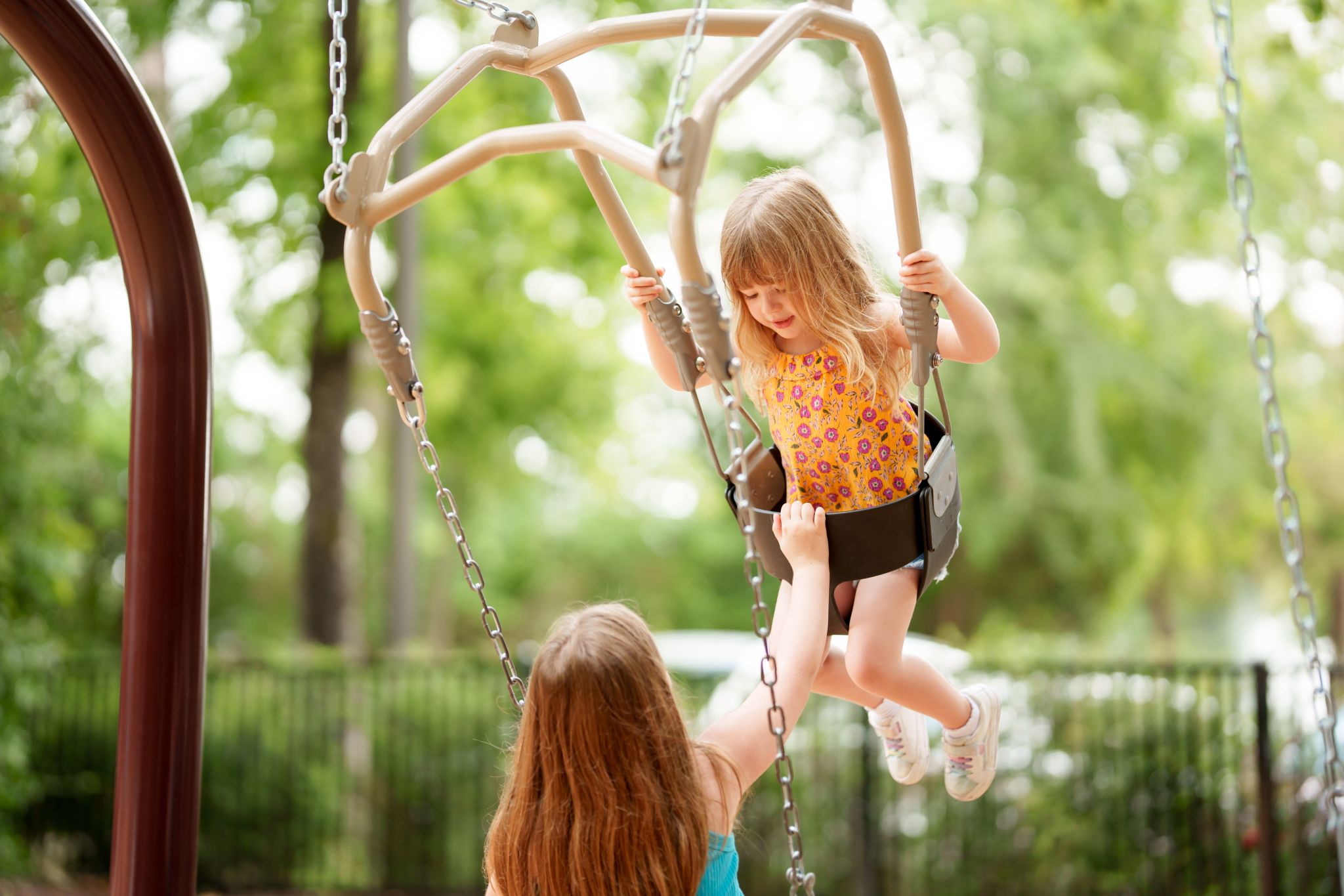 children swinging on the mom and me swing in The Falls at Imperial Oaks