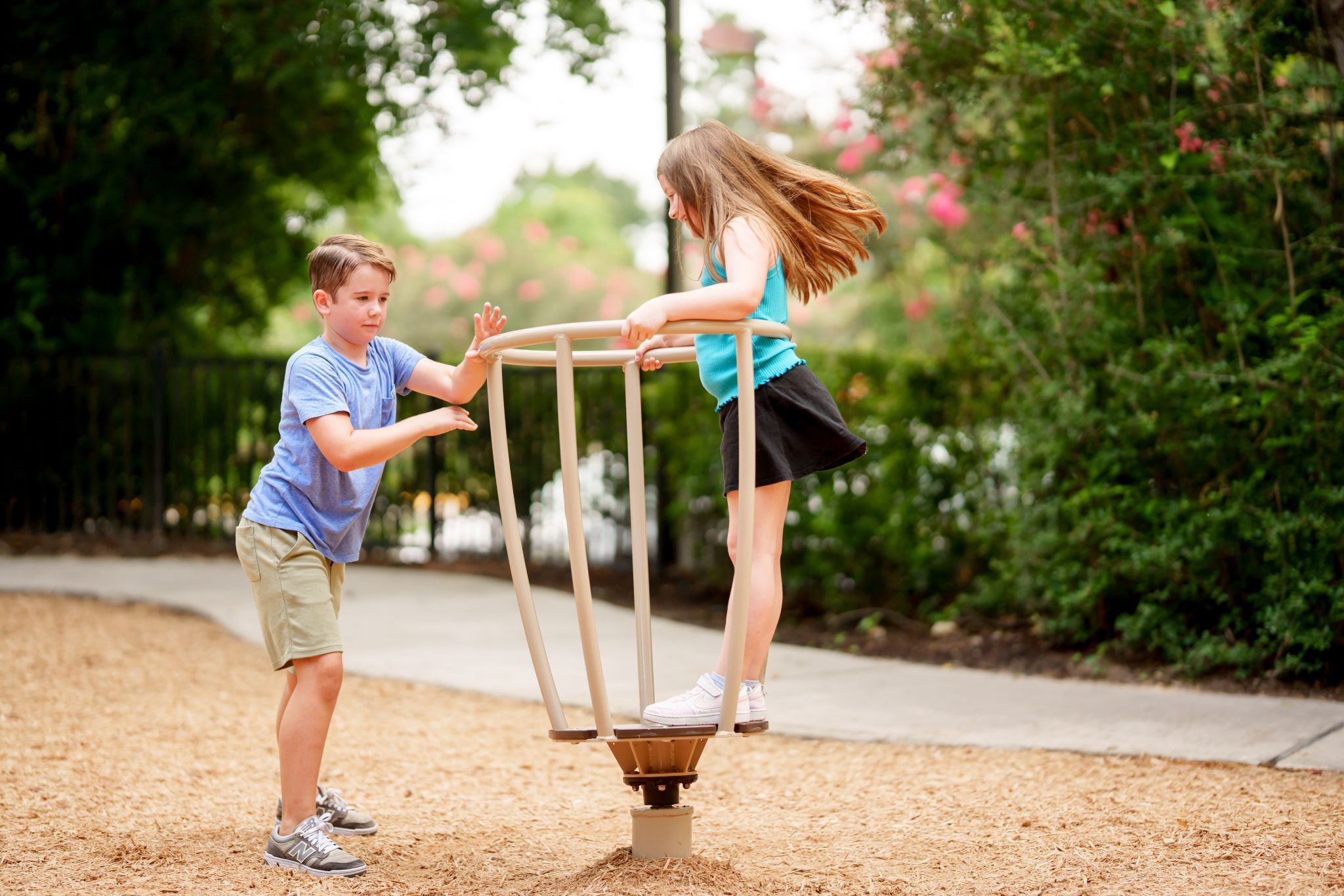 children playing on spinner in The Falls at Imperial Oaks