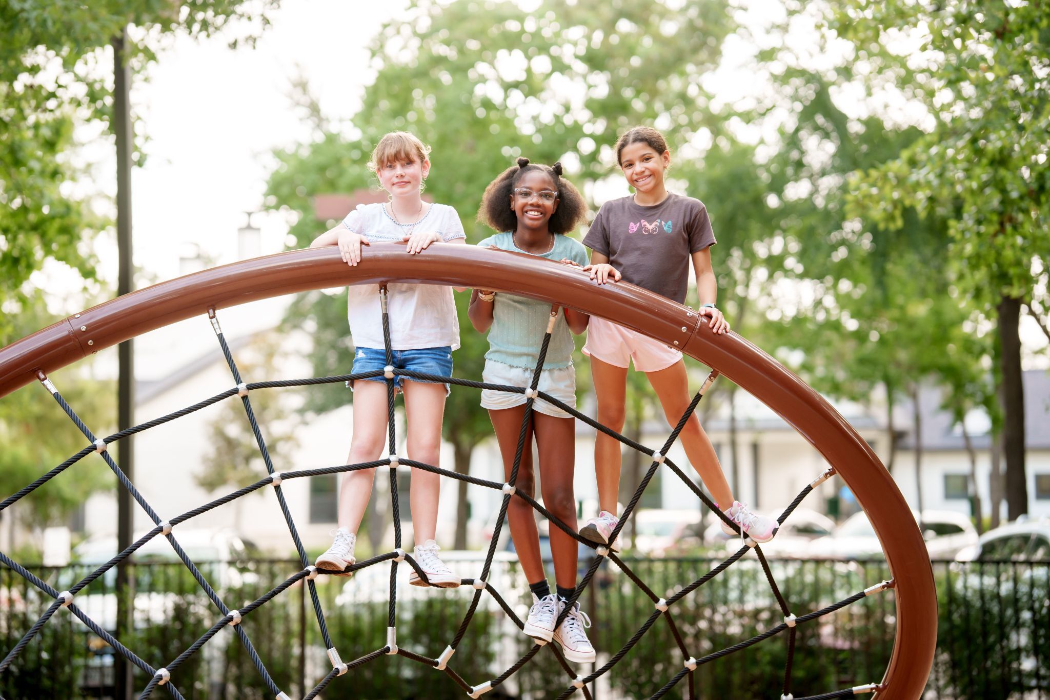 children smiling on the Ascend rope structure in The Falls at Imperial Oaks